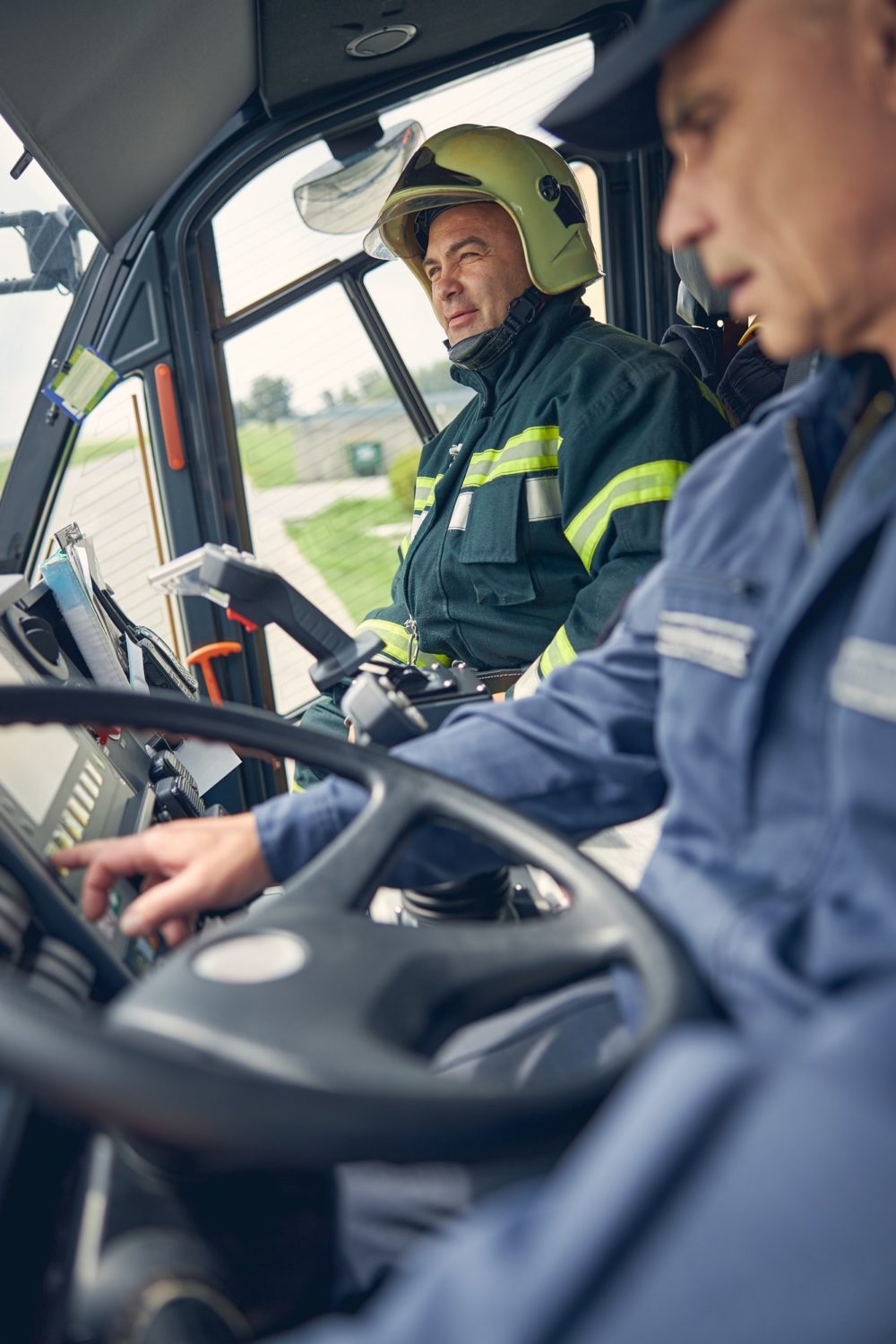 Portrait of two men sitting in the fire truck